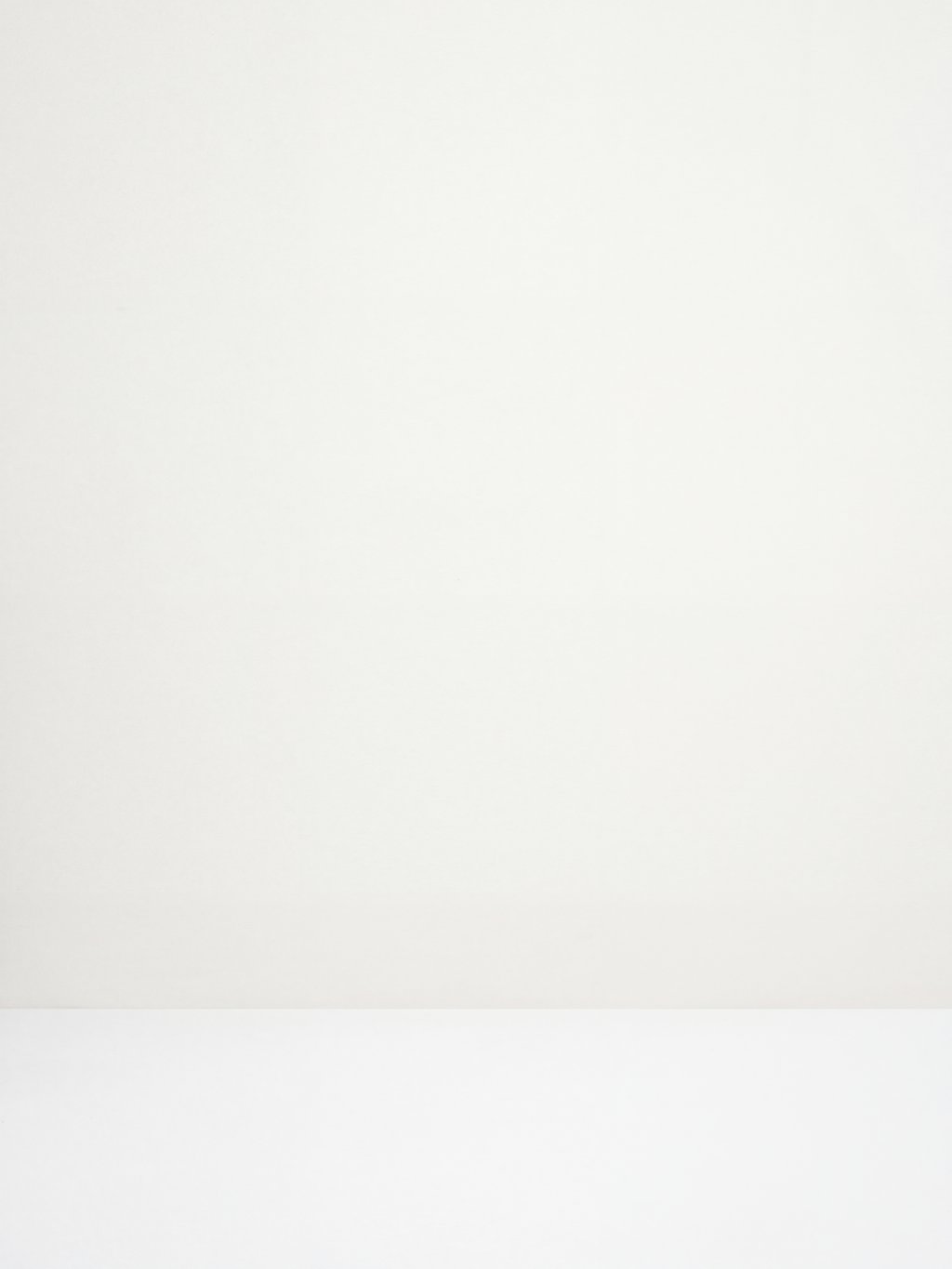 An empty cream studio wall and floor