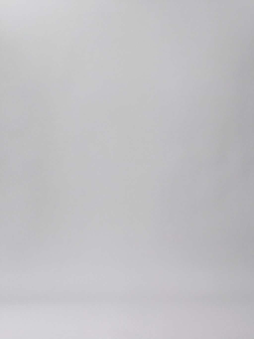 An empty light grey studio background with a soft gradient