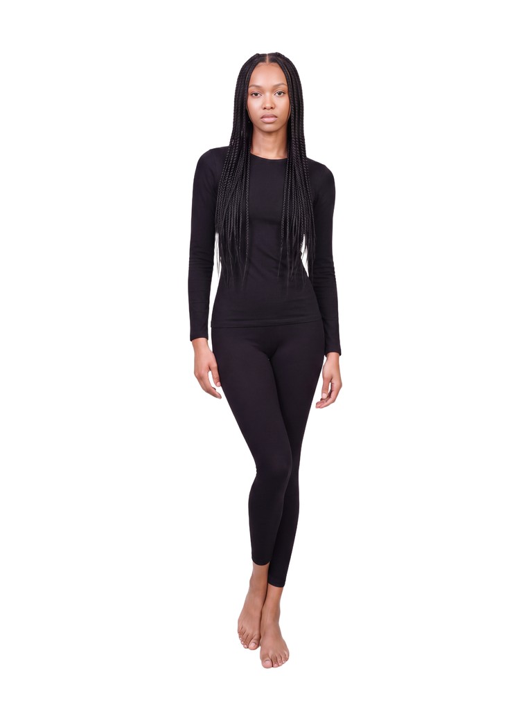 Amina facing the camera, full length, in a black long-sleeved top and black leggings