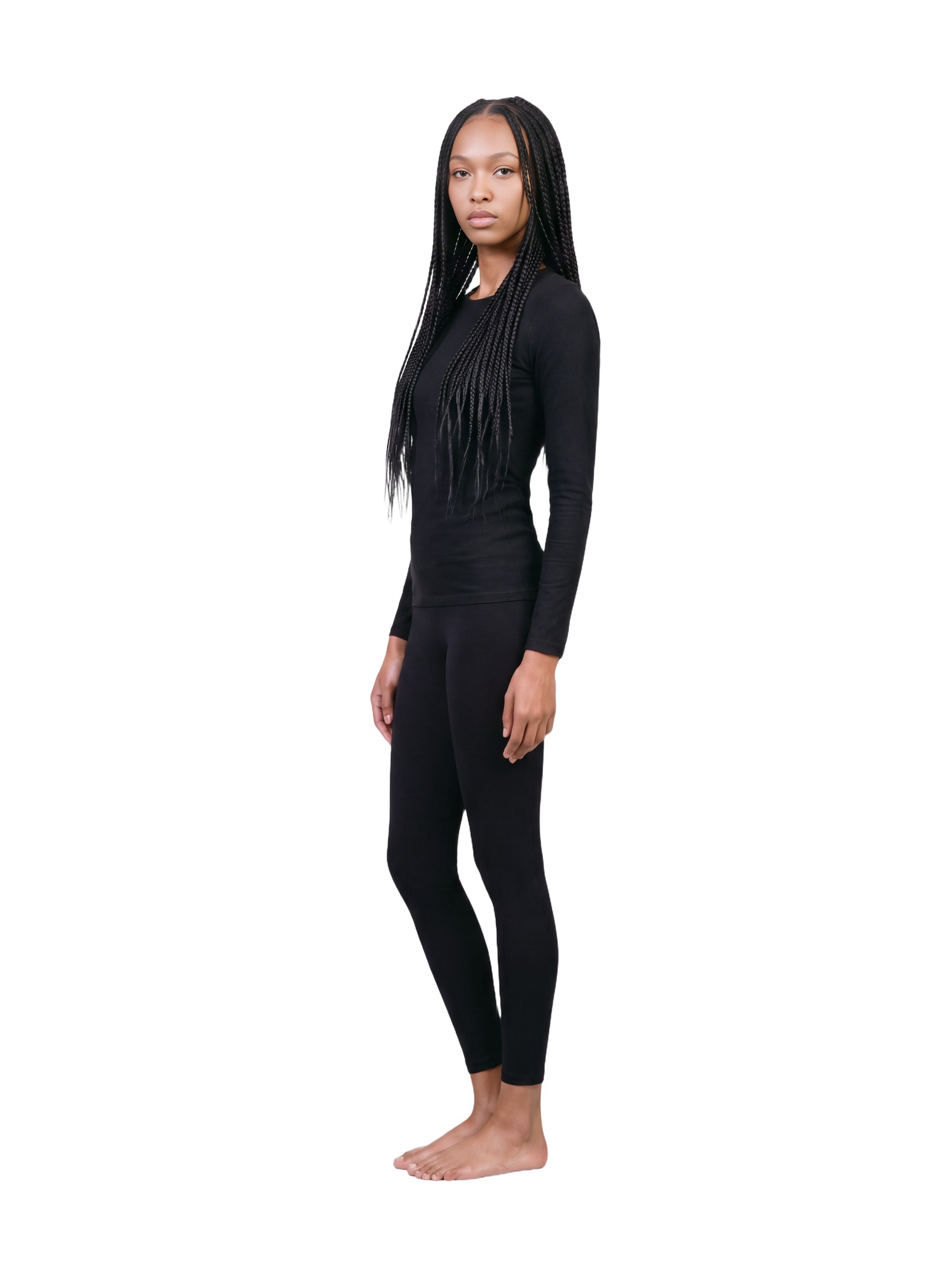 Amina in side profile, full length, in the same black outfit